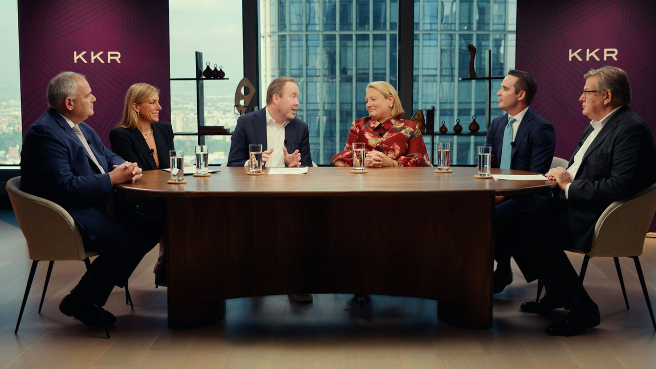 A panel of speakers sitting around a large table. 